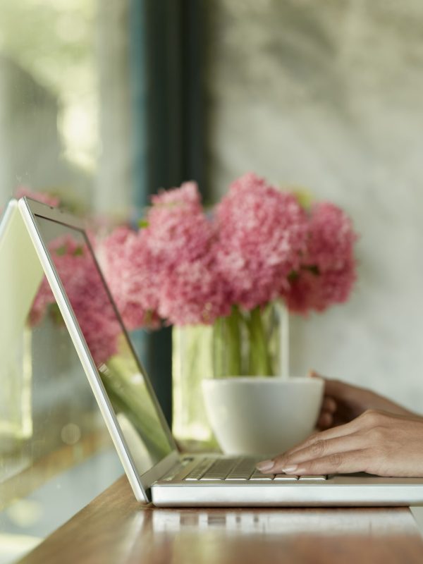 Closeup woman sitting at home office using laptop